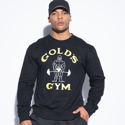 photo of male model wearing classic joe sweatshirt in black. classic joe logo in center with golds gym in yellow surrounding.