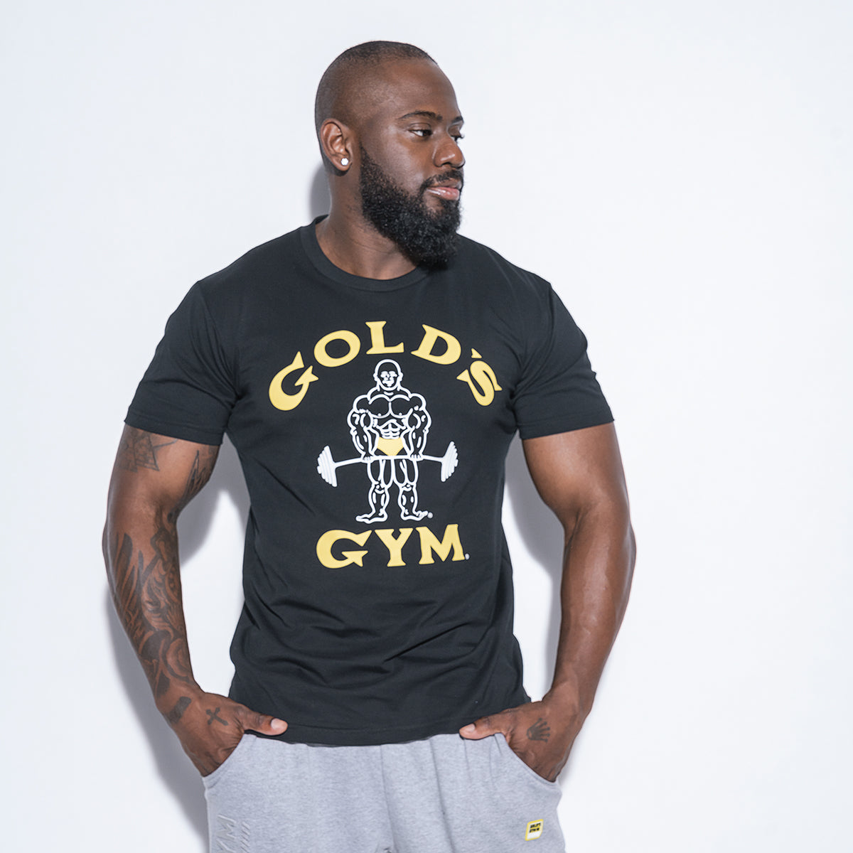 photo of male model wearing classic joe tee in black. classic joe logo in white with gold gym in yellow surrounding.