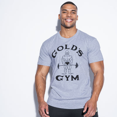 photo of male model wearing classic joe tee in grey. classic joe logo in black with gold gym in black surrounding.