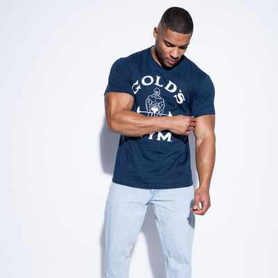 photo of male model wearing classic joe tee in navy. classic joe logo in white with gold gym in white surrounding.