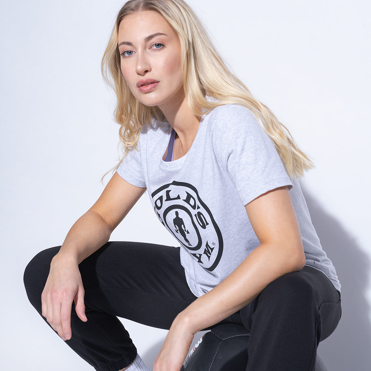 photo of female model wearing weight plate tee in grey. large weight plate logo on front in black.